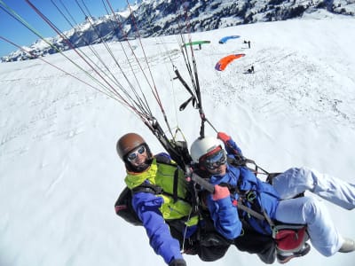 Winter tandem paragliding flight over Gstaad near Saanen, Switzerland