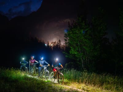 Descenso nocturno en bicicleta de montaña por el Col du Lautaret en Monêtier-les-Bains, cerca de Serre Chevalier