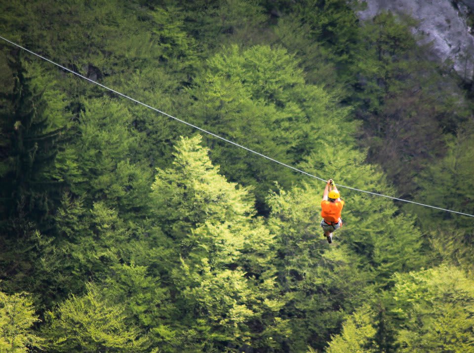 Man zip lining in the mountains of Bovec in Slovenia