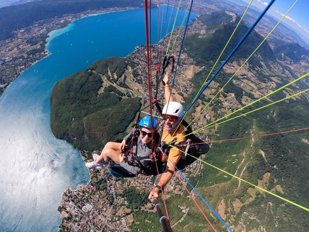 pilot and passenger paragliding over lake annecy
