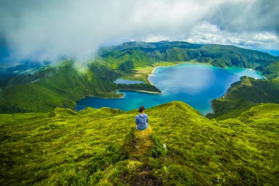 Una mujer contemplando el paisaje de Lagoa do Fogo en las Azores