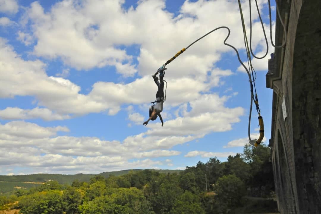 A woman doing bungee jumping from the Sainte-Eulalie Viaduct near Millau