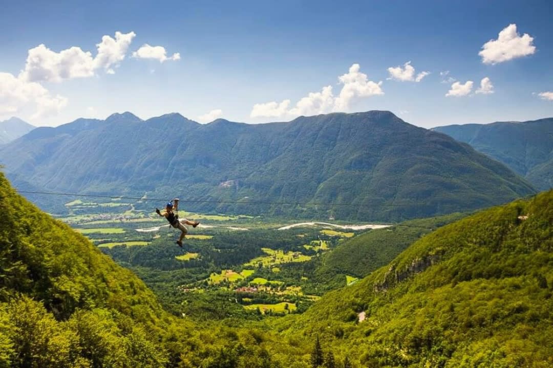Un hombre haciendo tirolesa en el monte Kanin, sobre Bovec