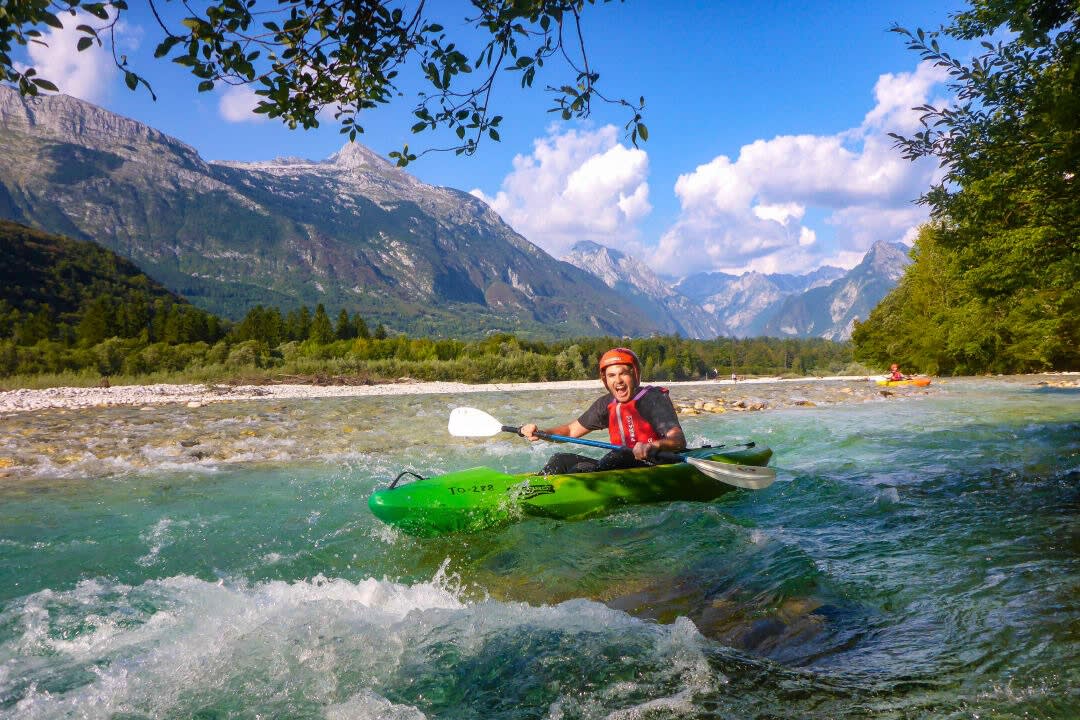 Un hombre practicando kayak de aguas bravas en el río Soča saliendo de Bovec