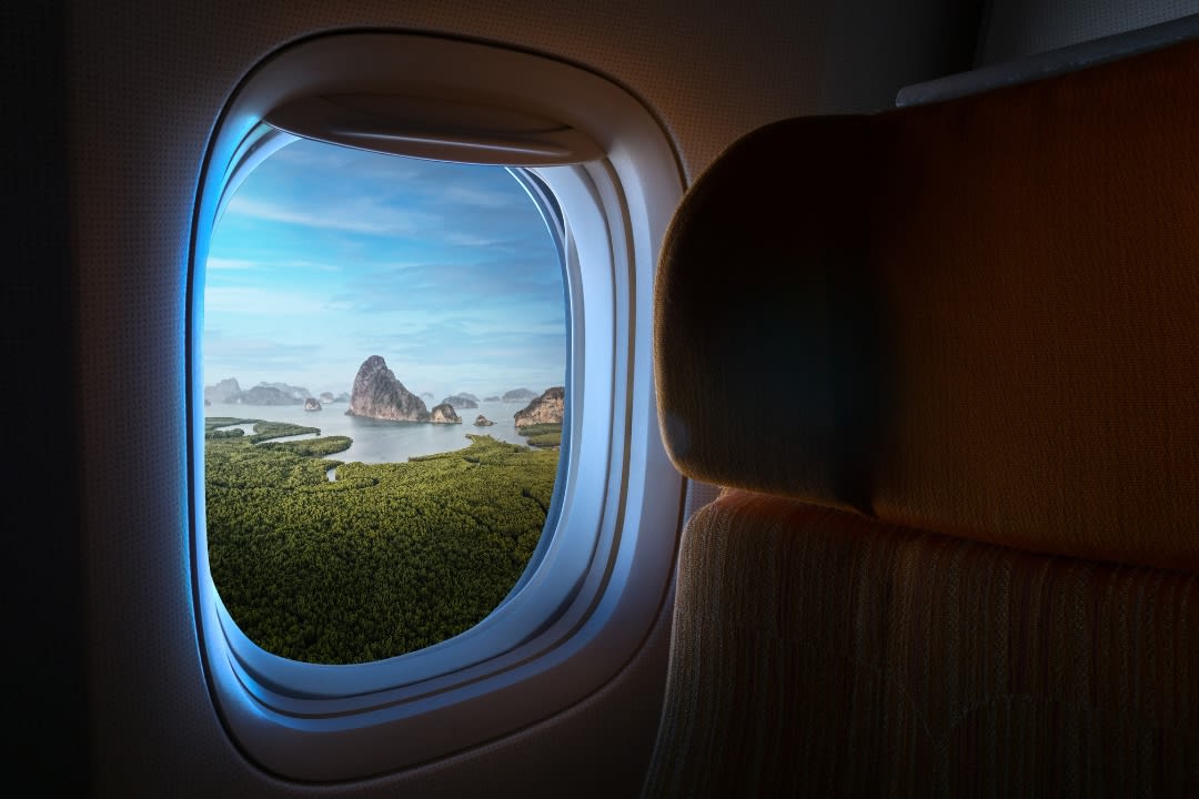 La ventana de un avión muestra paisajes de una isla