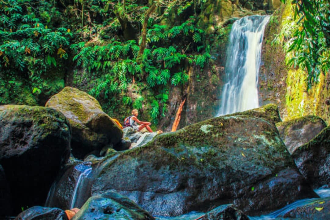 Una mujer haciendo una excursión guiada de un día completo al Salto do Prego desde Ponta Delgada en São Miguel, Azores