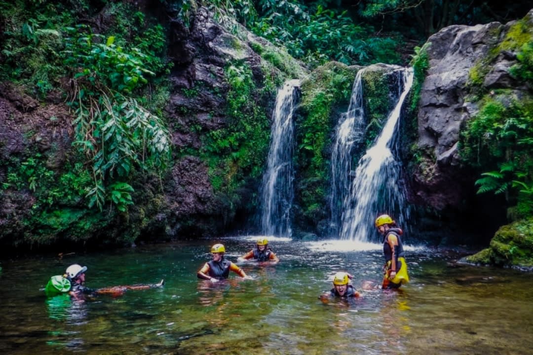 Una familia disfruta de una excursión de barranquismo en la Ribeira dos Caldeiroes en São Miguel, Azores