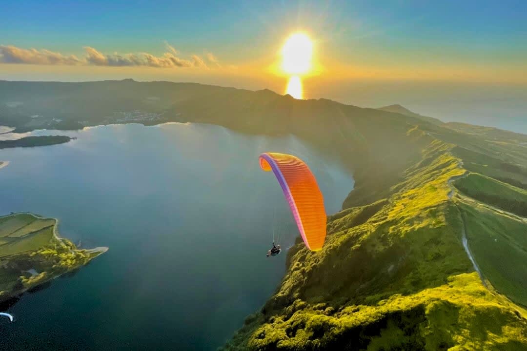 A man paragliding above São Miguel Island