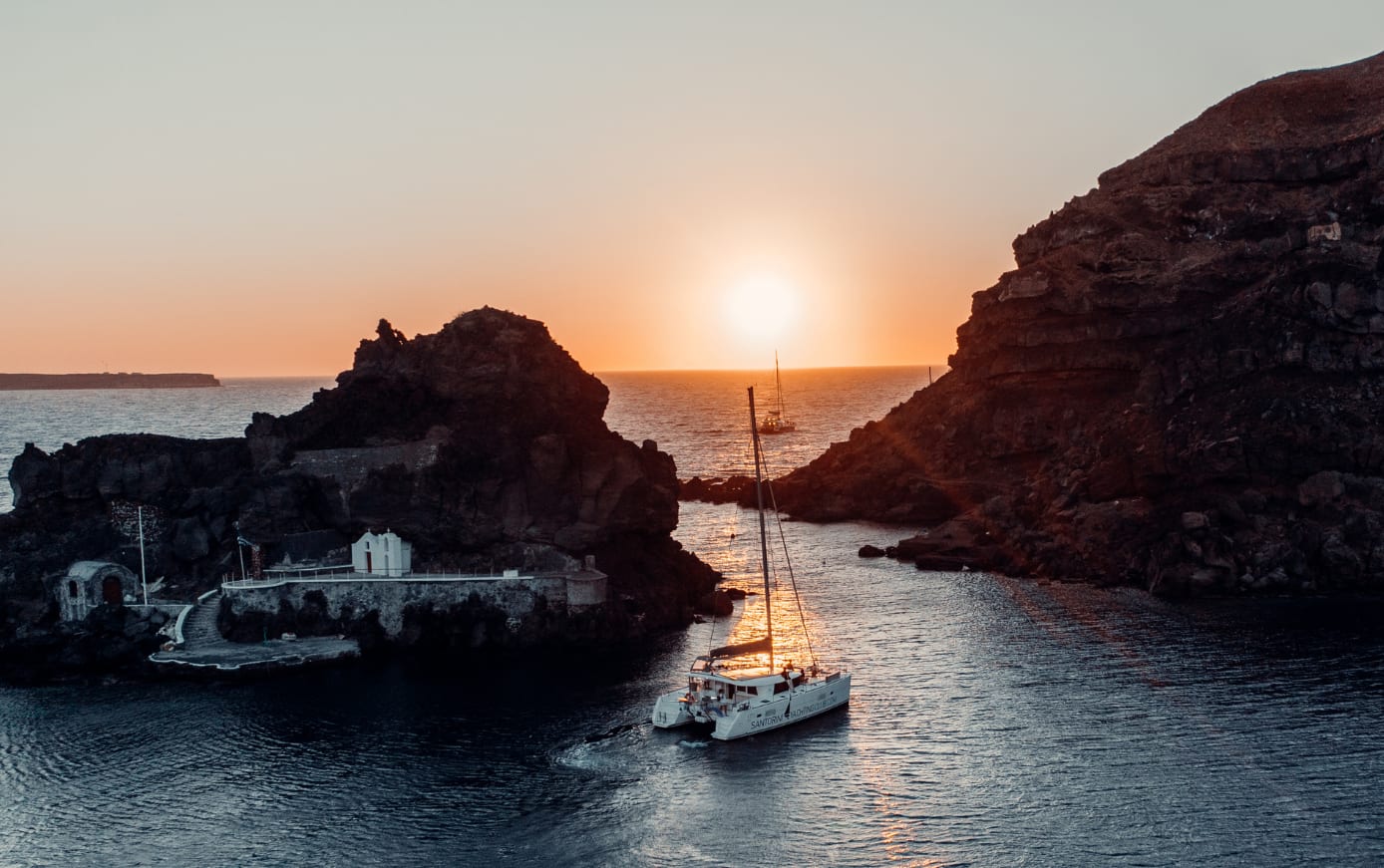 Crucero en catamarán al atardecer desde la bahía de Vlychada en Santorini