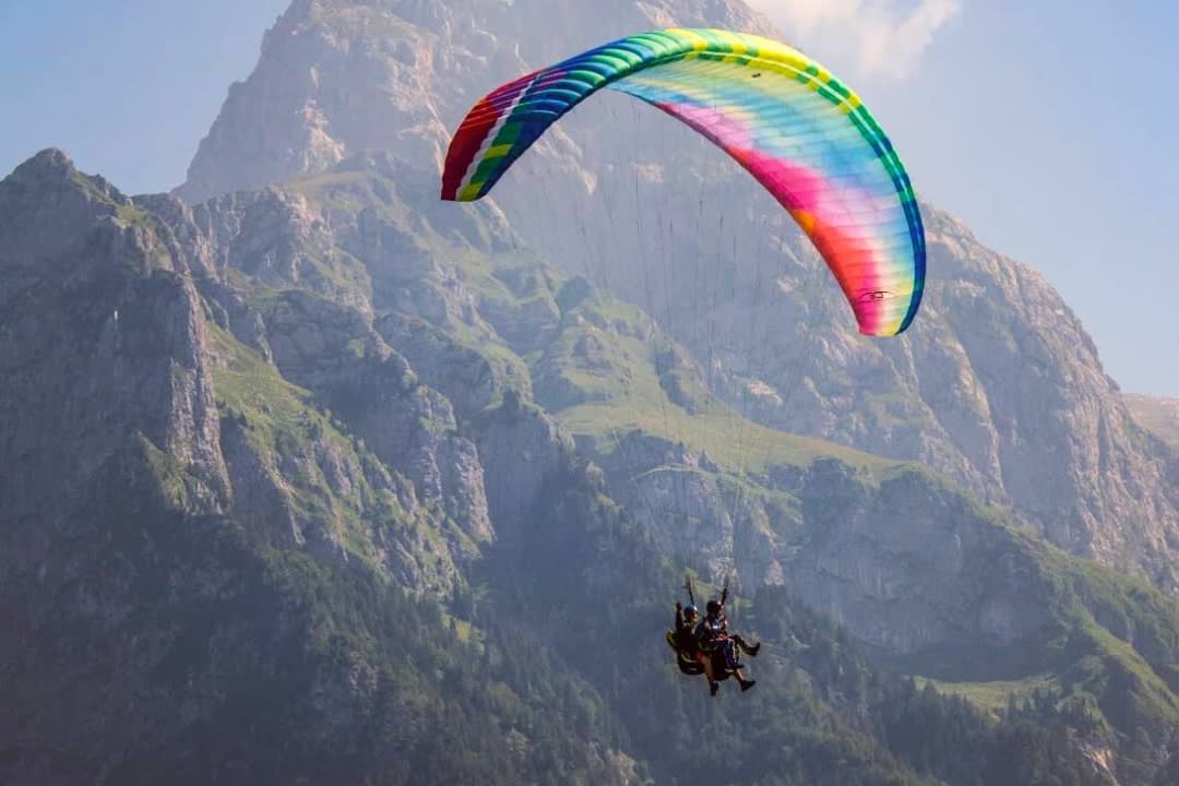 Un hombre realiza un vuelo en parapente biplaza sobre el valle de Soča desde Bovec