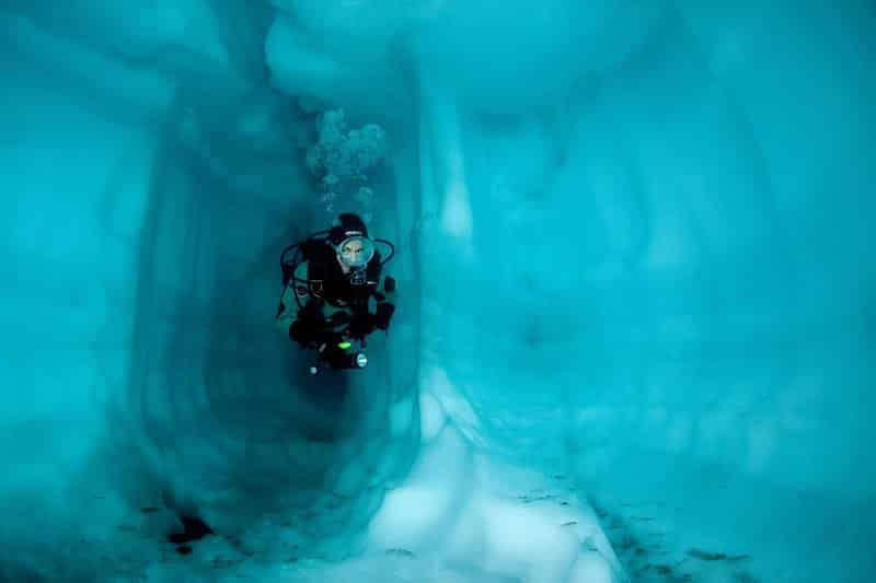Submarinista dentro de una cueva de hielo, lago Sassolo, valle de Sambuco, Tesino, Suiza