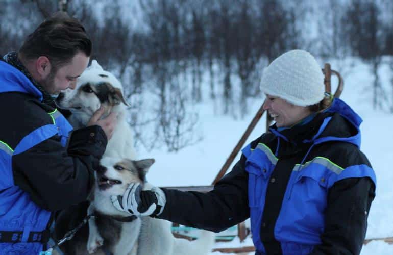 Participants au traîneau à chiens jouant avec les chiens