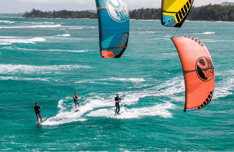 Trois kitesurfers sur l'eau