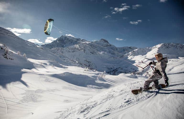 Snowkiter in den verschneiten Bergen von Brig, Schweiz