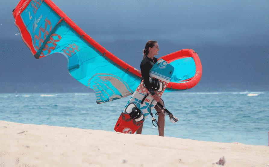 Kitesurfer mit Ausrüstung am Strand