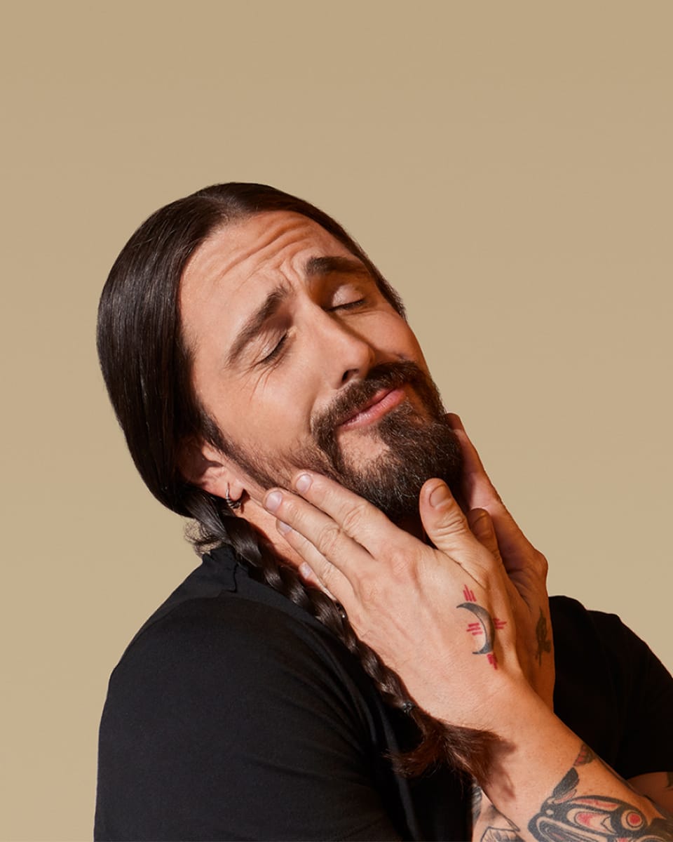 White male model holding onto his beard with both hands