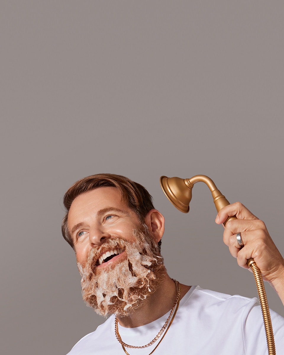 White male model using MANSCAPED® Beard Shampoo in his thick beard
