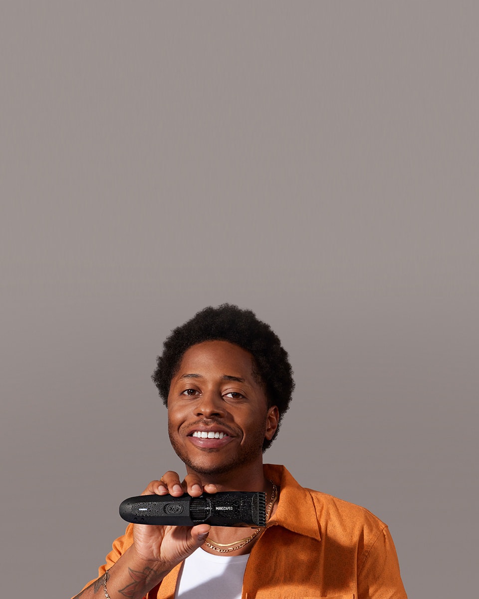 Black male model holding The Beard Hedger™ covered in water