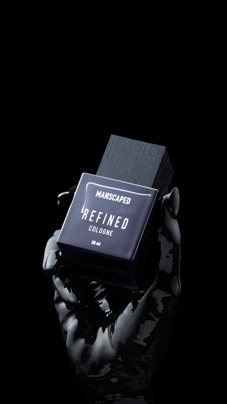 Refined® Cologne being held in fingertips of a black-painted hand