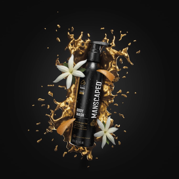 Refined® UltraPremium Body Wash laying in a gold splash of citrus rinds and jasmine flowers