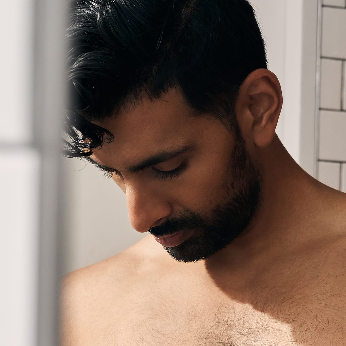 Male model looking down in the shower