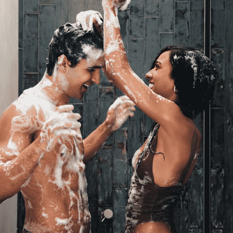 Male and female model wash themselves in the shower with MANSCAPED®'s Refined® Body Wash