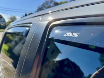 A very close-up photo of the passenger side windows, zommed into the AVS logo on one of the in-channel vent shades.