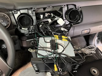 The kit’s wires, resting on top of the uninstalled stereo, and in the background is an open dashboard that seems a bit daunting.
