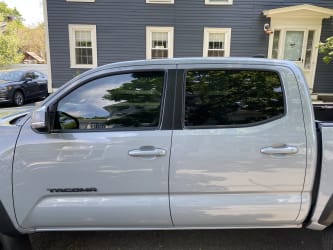 A zoomed in side-profile photo of the Tacoma with tint on the front window that matches the factory-supplied rear window tint.