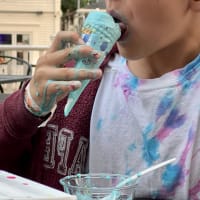 Our youngest eating an ice cream cone; the blue ice cream is melting faster than he can consume it, and it’s dripping down his hand making a perfect summertime mess.