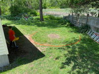 An area of our backyard with an orange spray painted circle marking where we’ll dig