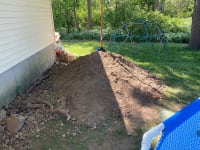 A large pile of dirt and rocks that came from digging the hole