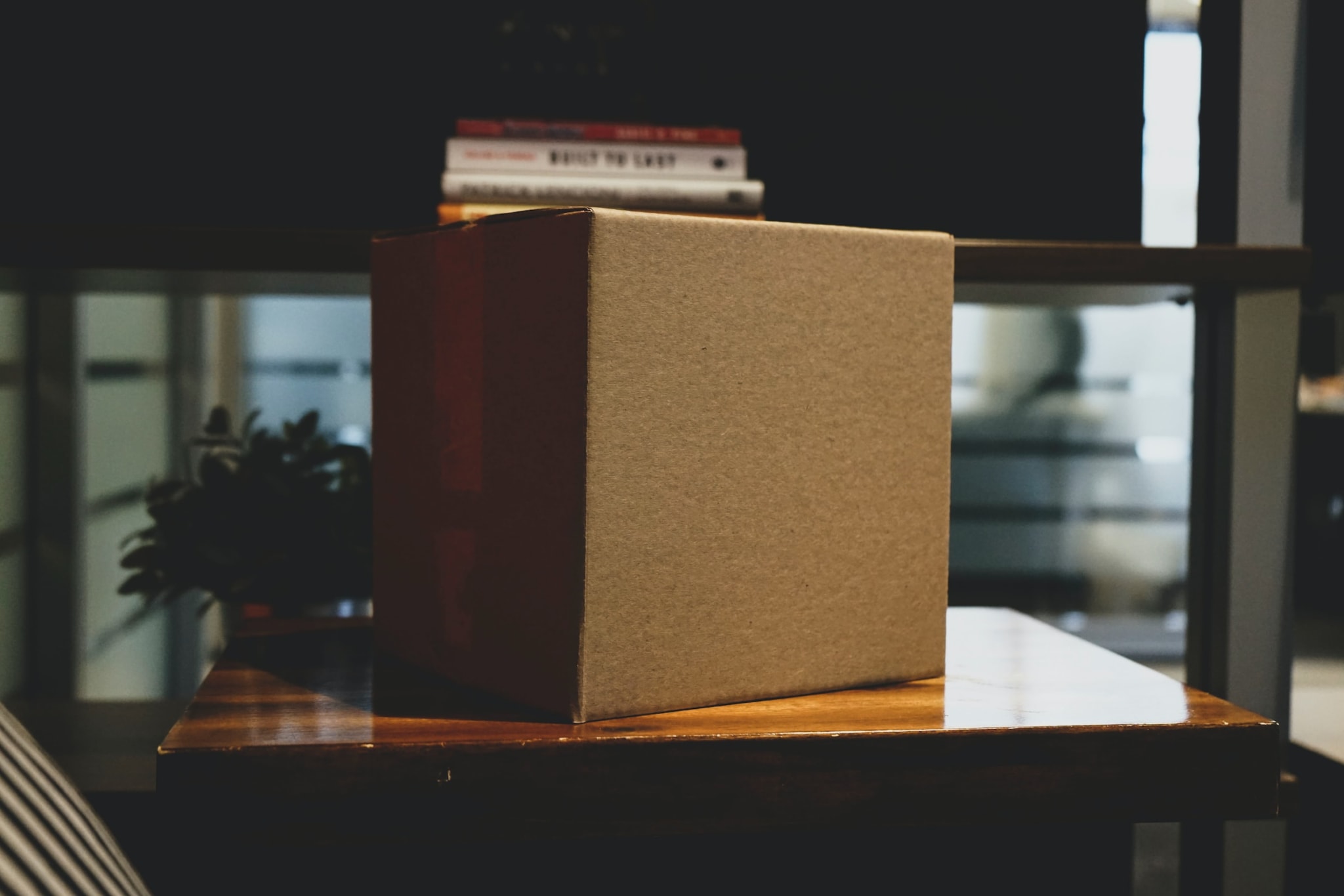 Una caja sobre una mesa y libros en el fondo.