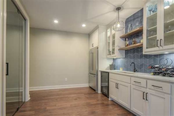 Basement wet bar with custom glass doors to wine cellar on the left.