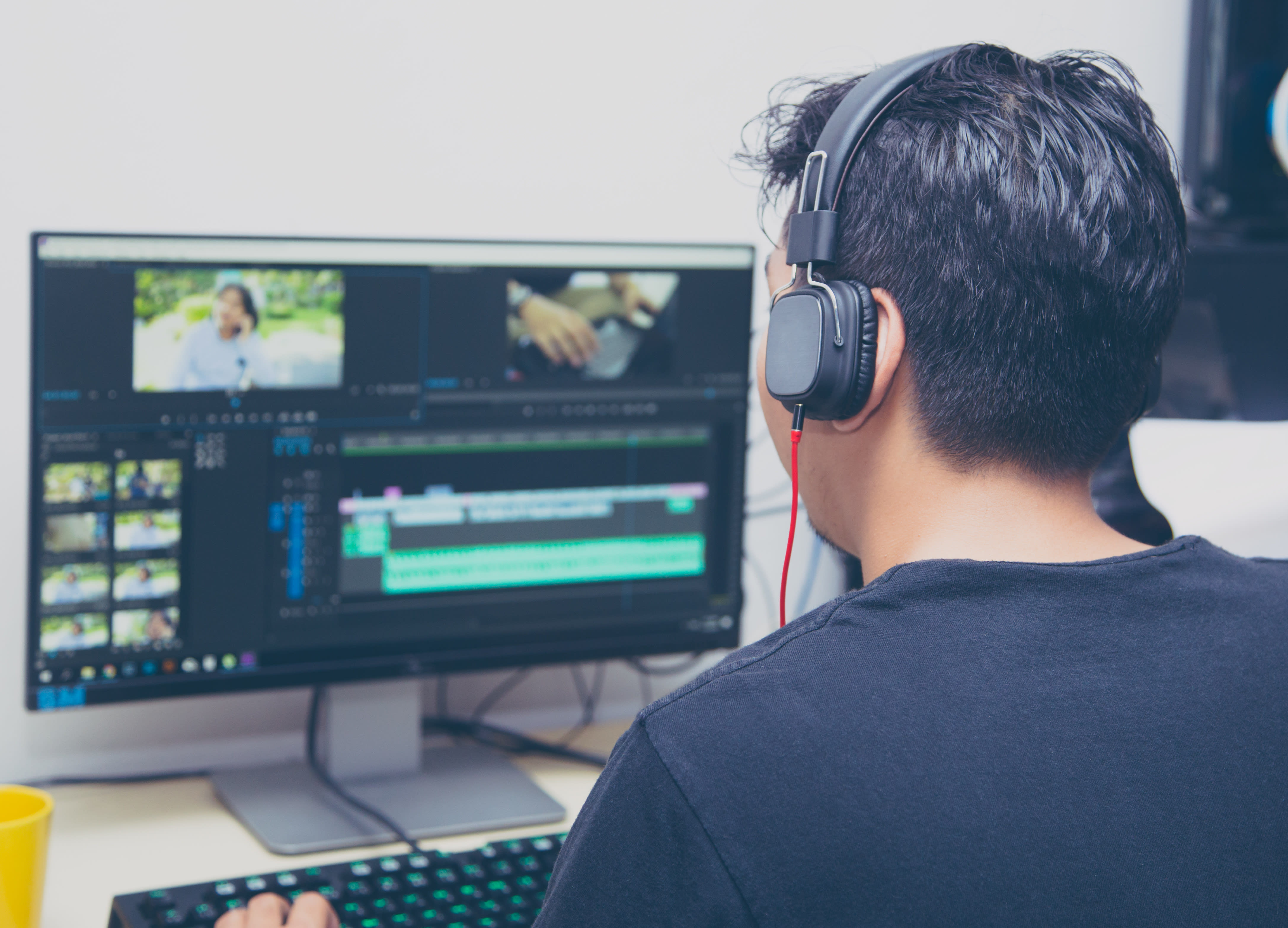 back view of video editor using computer