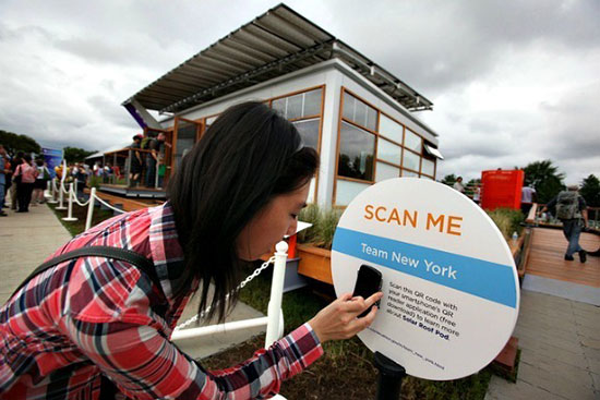 A woman scanning a QR code with her telephone