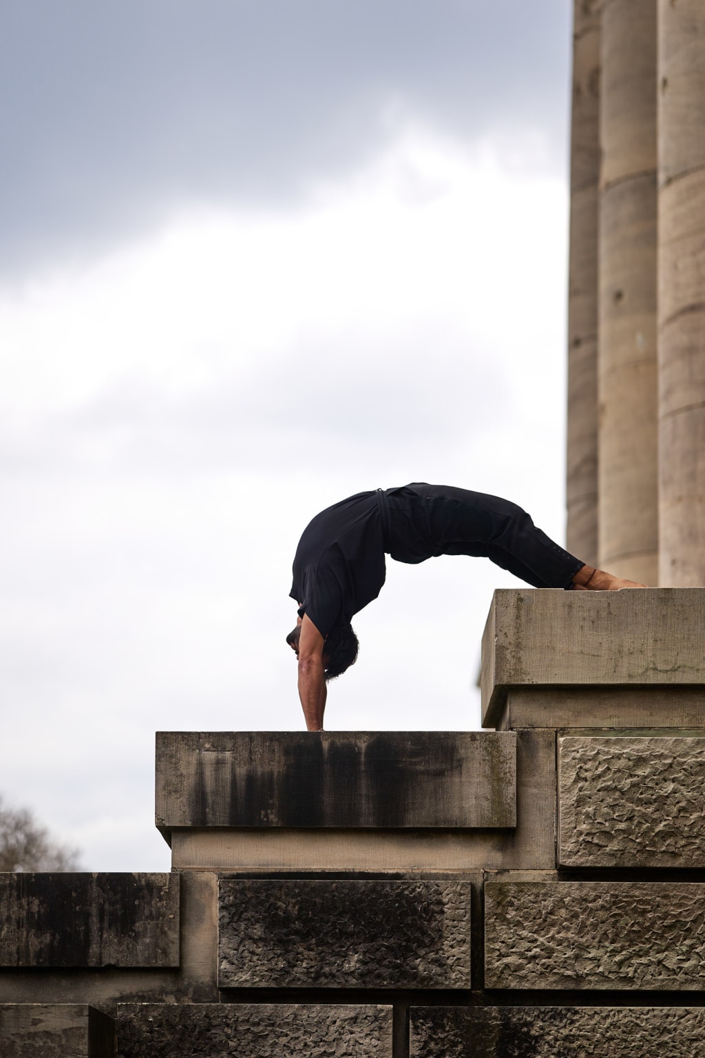 A Foto of @yogabynoah doing an extreme handstand variation