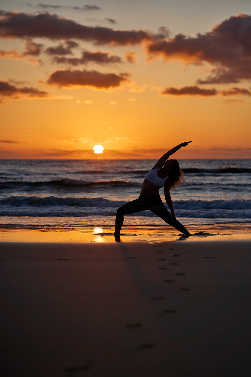 A Foto of @alexandrajacobyoga doing a Peaceful Warrior yoga pose at sunset