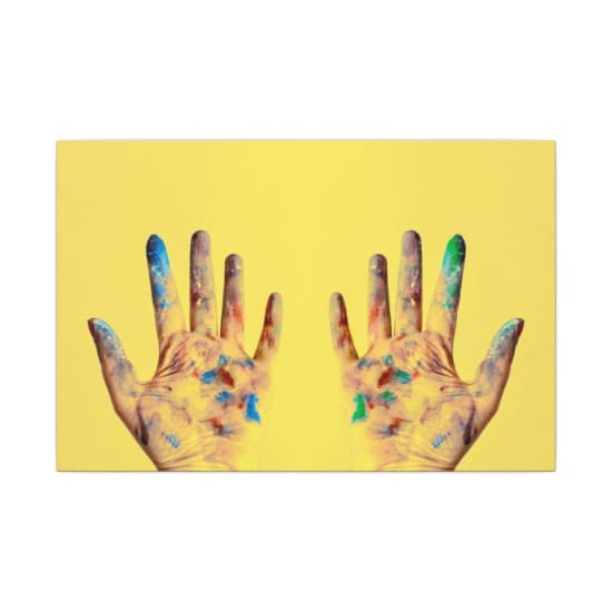 Colorful fingers spread against a bright yellow backdrop, showcasing creativity.