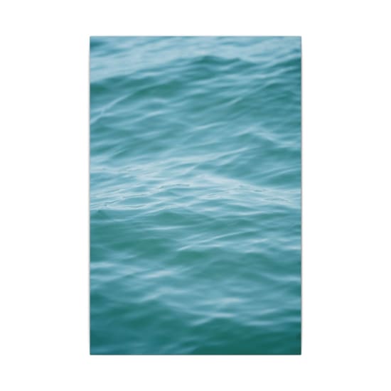A serene view of turquoise ocean waves with gentle ripples, suitable for mobile wallpaper.