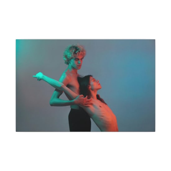 Two dancers perform an artistic pose, showcasing flexibility and elegance in a studio setting.