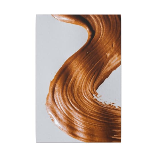 Close-up of an artistic abstract brown paint stroke creating a textured pattern.