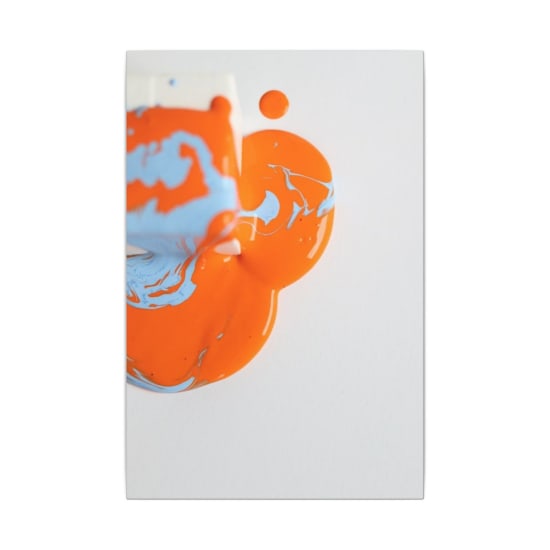 Vibrant orange and blue paint splash artfully spread on a white background, creating a striking abstract visual.