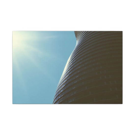 A modern skyscraper with unique curves and sun flare in a clear sky, showcasing architecture.