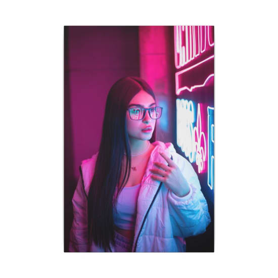 Trendy woman in glasses illuminated by vibrant neon lights, exuding a modern nightlife feel.