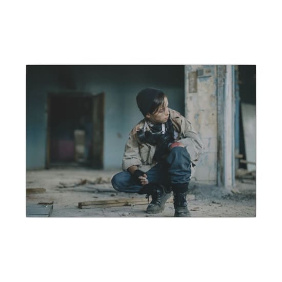 A young explorer in rough attire searches an abandoned urban ruin, evoking survival themes.