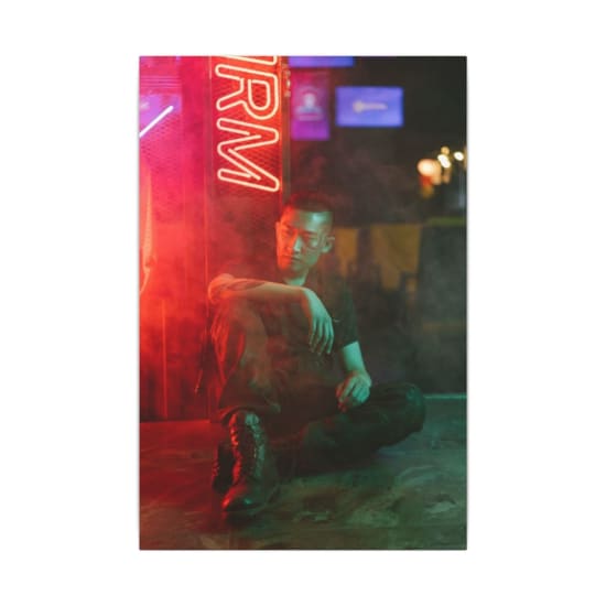 Asian man in a neon-lit cyberpunk setting, showcasing futuristic fashion and style.