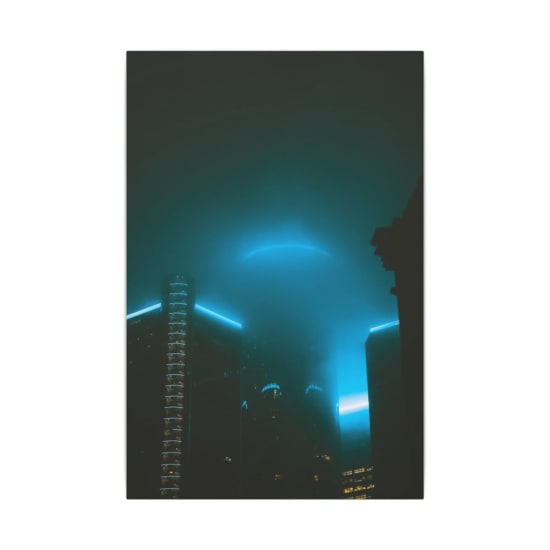 A captivating shot of illuminated skyscrapers shrouded in fog during nighttime, creating a mystical urban skyline.