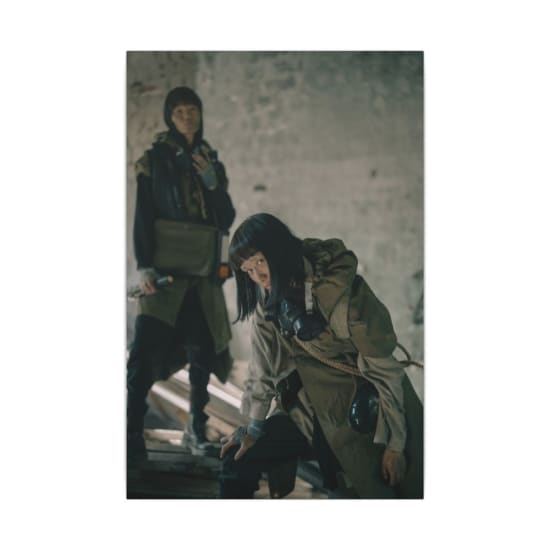 Two people in dystopian attire exploring an abandoned building.