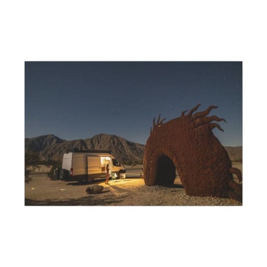 A peaceful night scene featuring a camper van and a sculpture at Galleta Meadows, California.